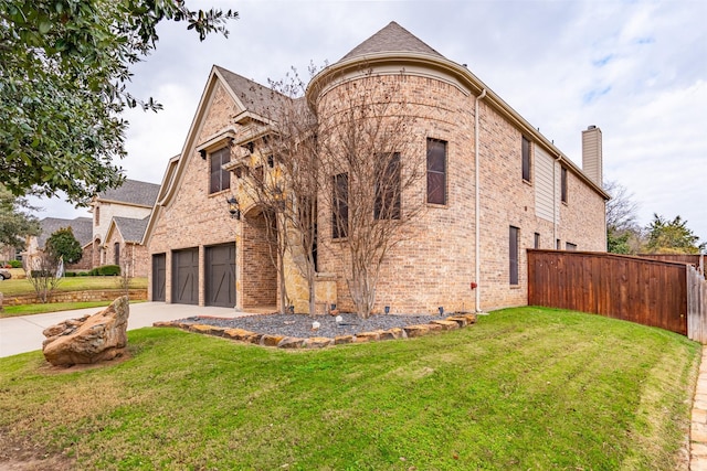 view of front facade featuring driveway, a chimney, brick siding, and a garage
