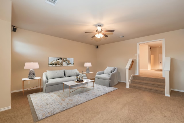 living room featuring carpet, a ceiling fan, baseboards, and stairway