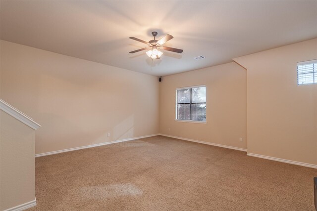 carpeted empty room featuring ceiling fan and a healthy amount of sunlight