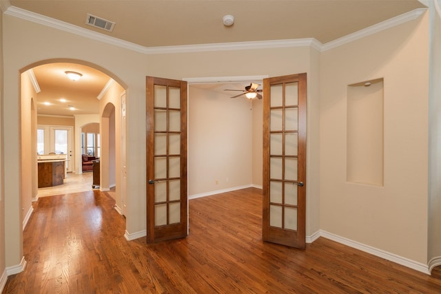 empty room with french doors, hardwood / wood-style flooring, ceiling fan, and ornamental molding