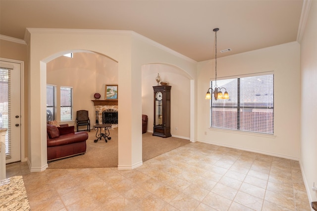 interior space featuring a fireplace, light carpet, crown molding, and a notable chandelier