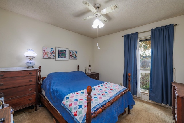 bedroom with ceiling fan, light colored carpet, and a textured ceiling