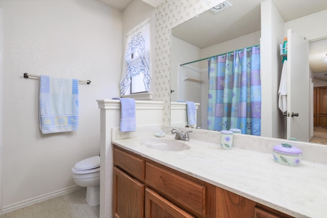 bathroom with vanity, curtained shower, toilet, and a textured ceiling