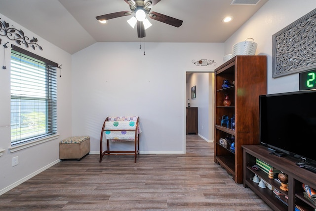 living area featuring hardwood / wood-style floors, vaulted ceiling, and ceiling fan