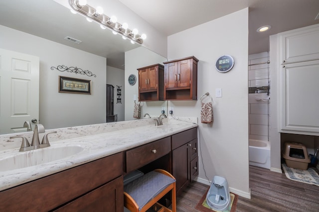 bathroom with hardwood / wood-style floors, vanity, and bathtub / shower combination