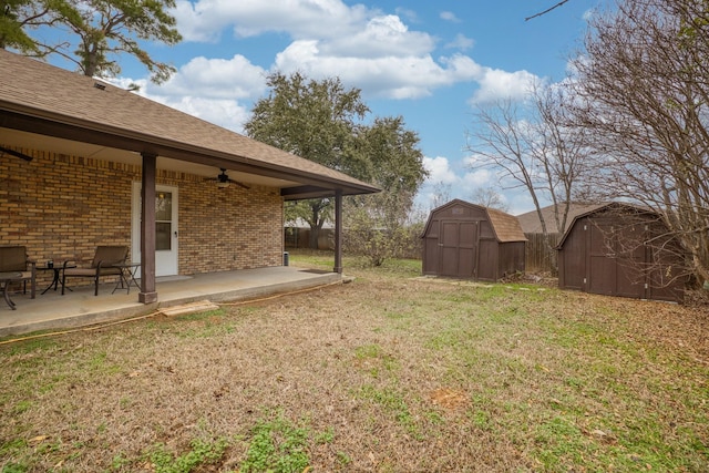 view of yard with a shed, ceiling fan, and a patio area