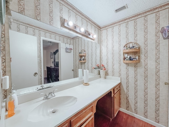 bathroom featuring vanity, hardwood / wood-style floors, and a textured ceiling