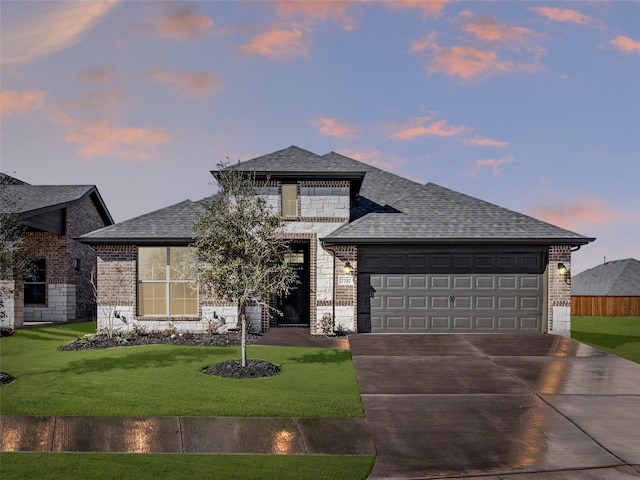 view of front of house featuring a garage and a lawn