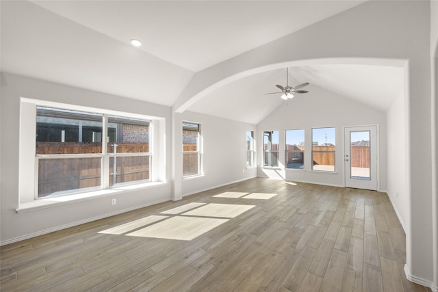 unfurnished living room with ceiling fan, lofted ceiling, and light wood-type flooring