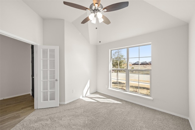 carpeted empty room featuring ceiling fan and vaulted ceiling