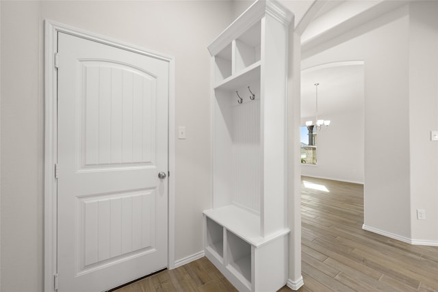 mudroom with a notable chandelier and light wood-type flooring