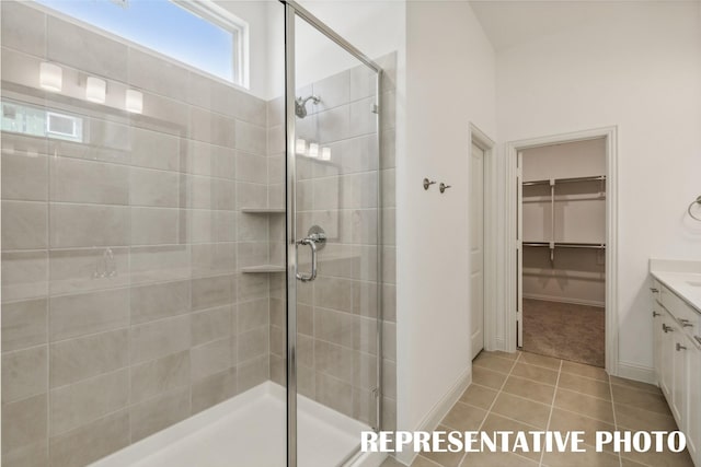 bathroom featuring tile patterned flooring, vanity, and a shower with door