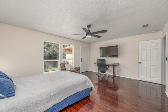 bedroom with ceiling fan, a textured ceiling, and dark wood-type flooring