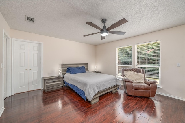 bedroom featuring ceiling fan, dark hardwood / wood-style floors, a textured ceiling, and a closet