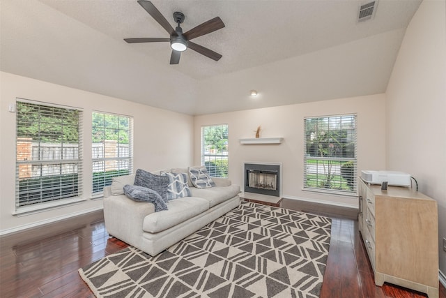 living room featuring a textured ceiling, ceiling fan, dark wood-type flooring, and lofted ceiling