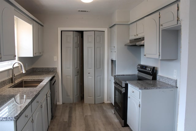 kitchen featuring sink, light hardwood / wood-style flooring, stone counters, stainless steel appliances, and white cabinets