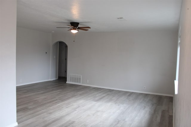 empty room with ceiling fan and light hardwood / wood-style flooring