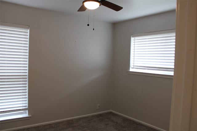 unfurnished room with dark carpet and ceiling fan