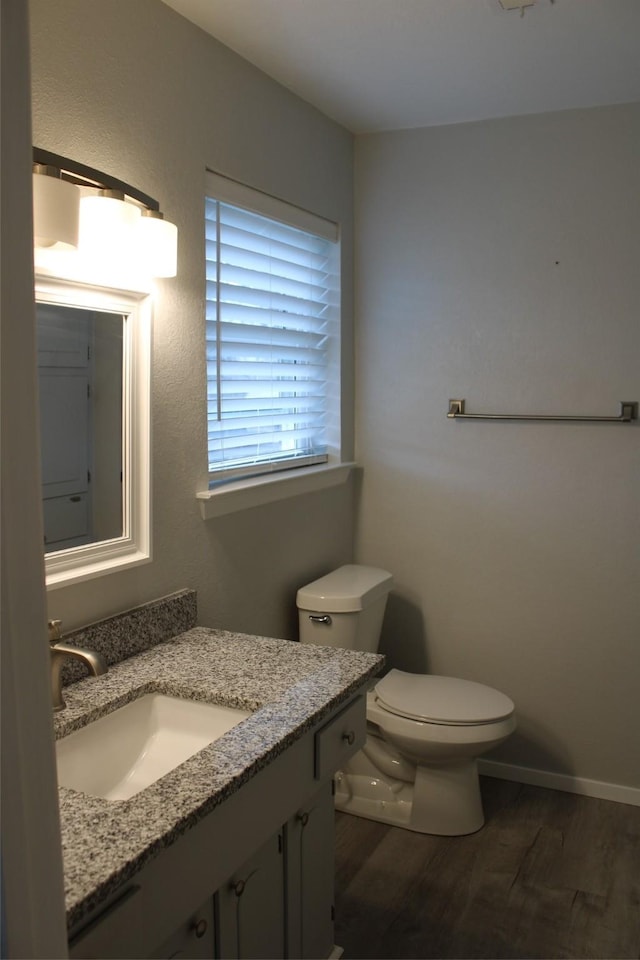 bathroom featuring wood-type flooring, toilet, and vanity