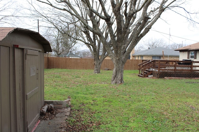 view of yard featuring a storage unit and a deck