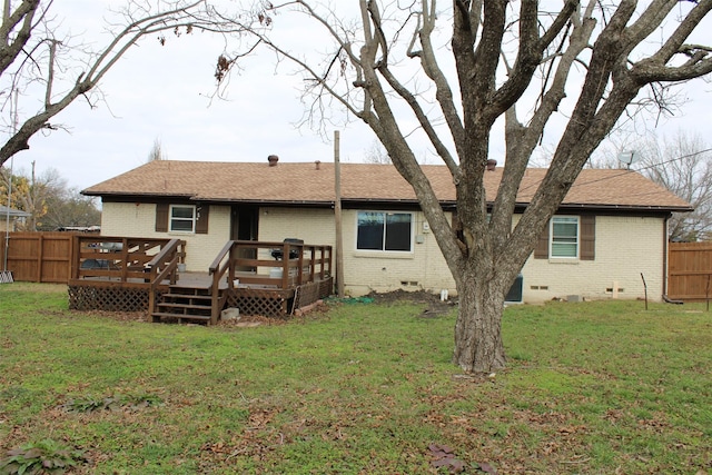 back of house featuring a wooden deck and a yard