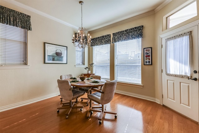 dining space featuring a notable chandelier, baseboards, ornamental molding, and wood finished floors