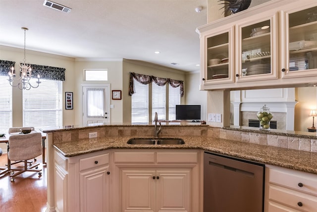 kitchen with dishwashing machine, sink, hardwood / wood-style flooring, ornamental molding, and stone countertops