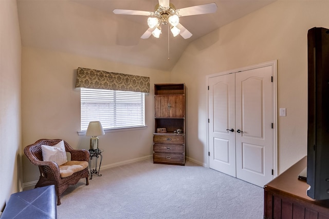 sitting room featuring a ceiling fan, light colored carpet, vaulted ceiling, and baseboards