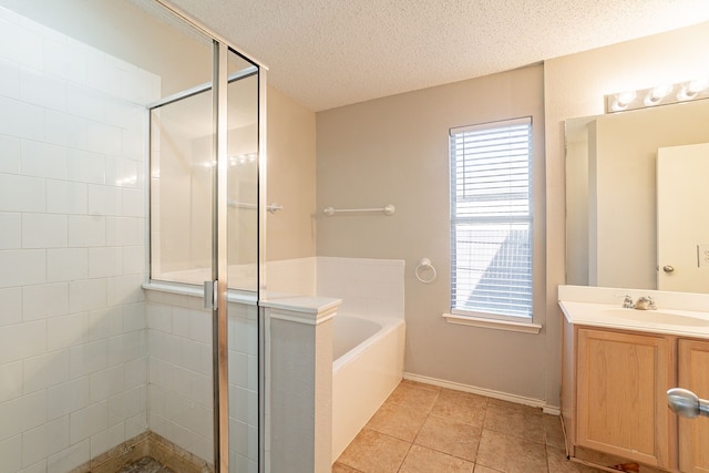 bathroom with tile patterned floors, independent shower and bath, a textured ceiling, and vanity