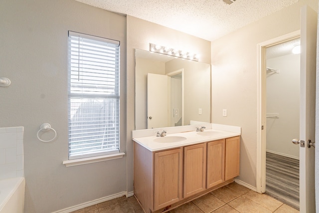 bathroom with vanity, tile patterned floors, and a textured ceiling