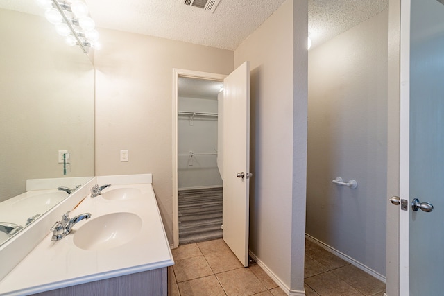 bathroom featuring vanity, tile patterned flooring, and a textured ceiling