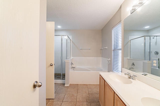 bathroom featuring tile patterned flooring, vanity, independent shower and bath, and a textured ceiling