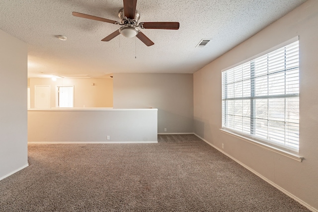 carpeted empty room with ceiling fan and a textured ceiling