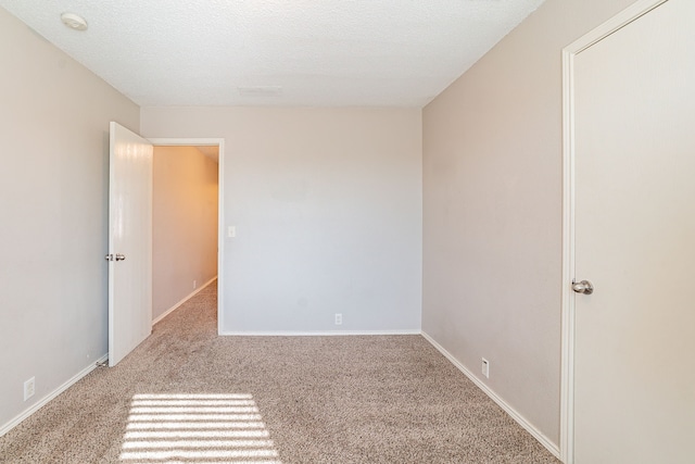 carpeted empty room with a textured ceiling