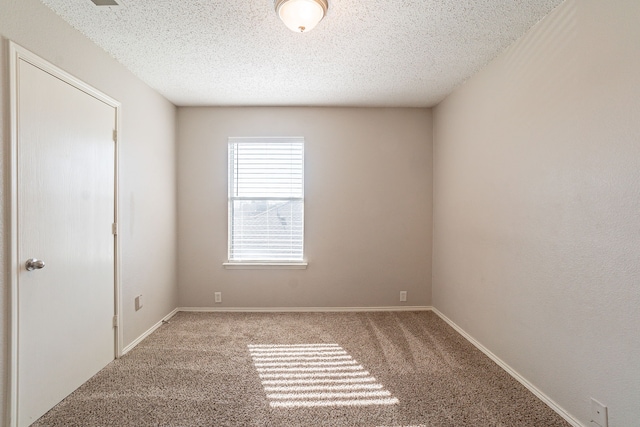 unfurnished room featuring carpet and a textured ceiling