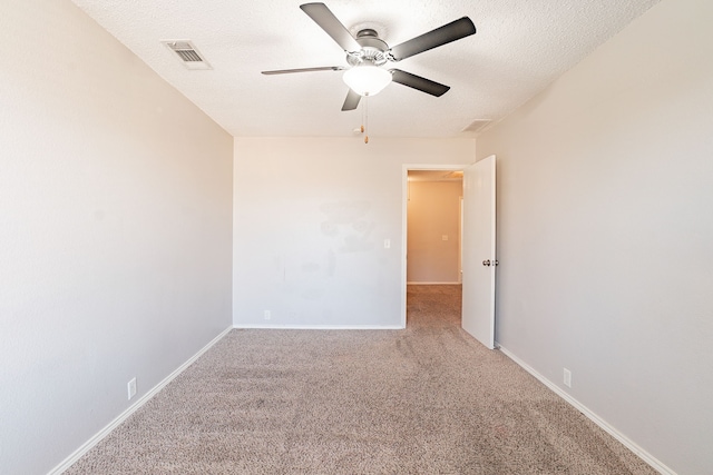 carpeted empty room with ceiling fan and a textured ceiling