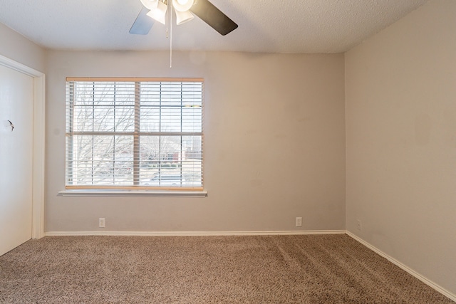 carpeted spare room with ceiling fan and a textured ceiling