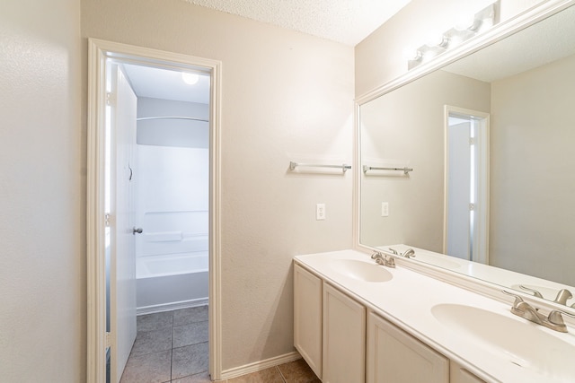 bathroom featuring tile patterned flooring, vanity, and a textured ceiling