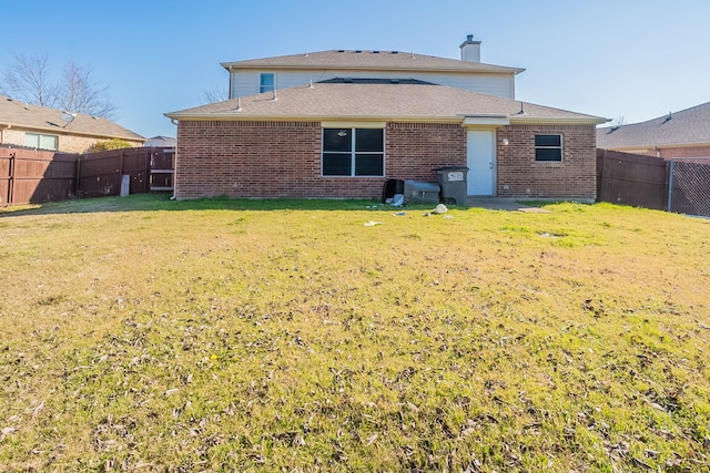 rear view of property with a lawn