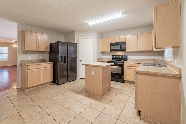 kitchen with sink, light brown cabinets, light tile patterned floors, a kitchen island, and black appliances