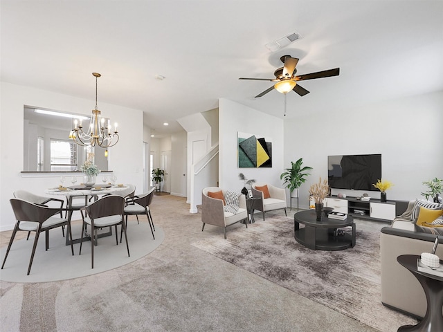 carpeted living room featuring ceiling fan with notable chandelier