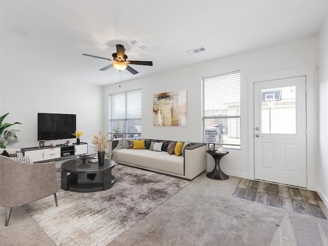 living room featuring ceiling fan and carpet