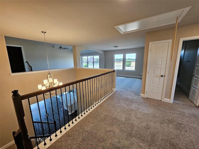 hallway with a notable chandelier and carpet floors