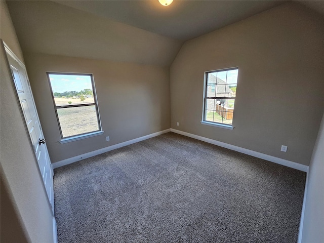 unfurnished room with dark colored carpet and vaulted ceiling