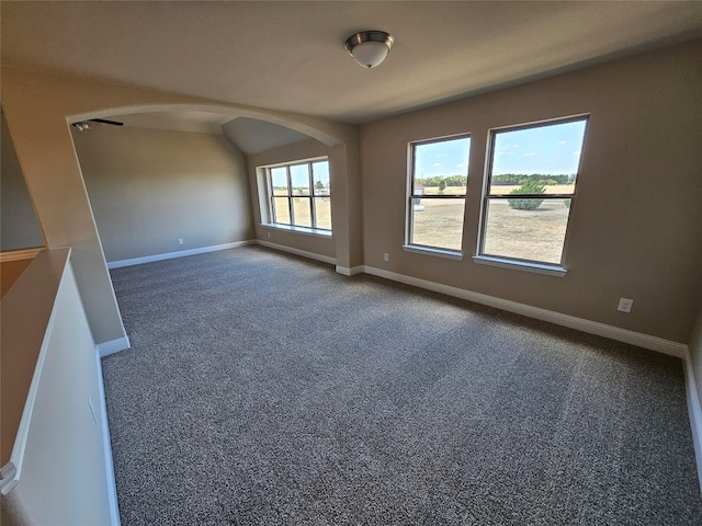 carpeted empty room with vaulted ceiling