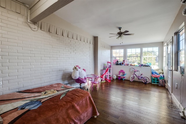 bedroom with ceiling fan, brick wall, and dark hardwood / wood-style floors