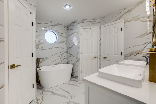 bathroom with a washtub, vanity, and tile walls