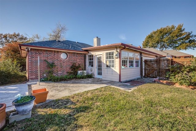 back of house with a patio area and a yard