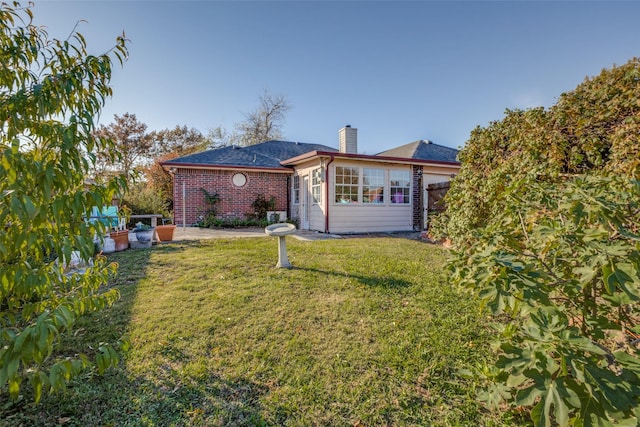 rear view of property featuring a lawn