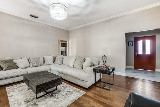 living room featuring ornamental molding, dark hardwood / wood-style floors, and an inviting chandelier